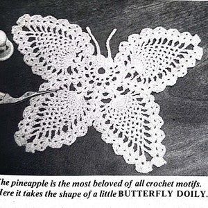 Peut inclure: Un napperon blanc en forme de papillon, crocheté avec des motifs ajourés complexes. Le napperon a la forme d'un papillon, avec des ailes et des antennes détaillées. Des ciseaux et un dé à coudre sont à côté du napperon. Le texte dit, "Here it takes the shape of a little BUTTERFLY DOILY."