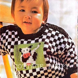 Puede incluir: Un niño lleva un suéter a cuadros blanco y negro con un diseño de vaca verde. El suéter tiene un botón en el hombro. El texto "Cow Sweater" y "See Page 97" es visible en la esquina superior derecha de la imagen.