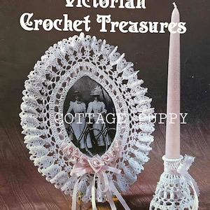 Może przedstawiać: Antyczna książka ze wzorami na szydełkowanie zatytułowana "Victorian Crochet Treasures" przedstawiająca białą, szydełkową ramkę na zdjęcie z czarno-białym zdjęciem dwóch kobiet oraz białą, szydełkową podstawkę na świecę.