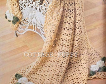 May include: A crocheted throw blanket in a beige color with a delicate floral design. The blanket is draped over a chair with a peacock design. The text "COTTAGE PUPPY" is visible on the blanket.