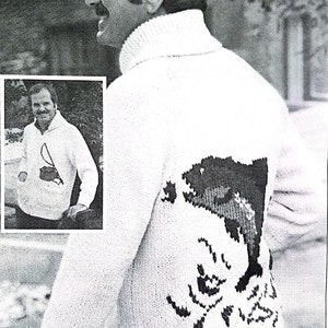 May include: A white knitted sweater with a black and white design of a fish on the back. The sweater has a high neck and long sleeves.