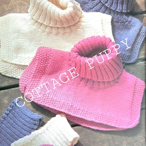 May include: Three knitted neck warmers in white, pink and blue, and three matching knitted wrist warmers. The neck warmers are folded over and the wrist warmers are laid flat.