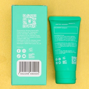 Pu&ograve; includere: Un tubo verde di crema per le mani con le parole "UNITED AGAINST GRAVITY" stampate sul davanti. Il tubo &egrave; etichettato con un codice QR e icone di social media. Il retro della scatola contiene informazioni sul prodotto, tra cui il produttore, il distributore e le informazioni di contatto. La scatola contiene anche un codice QR e icone di social media.