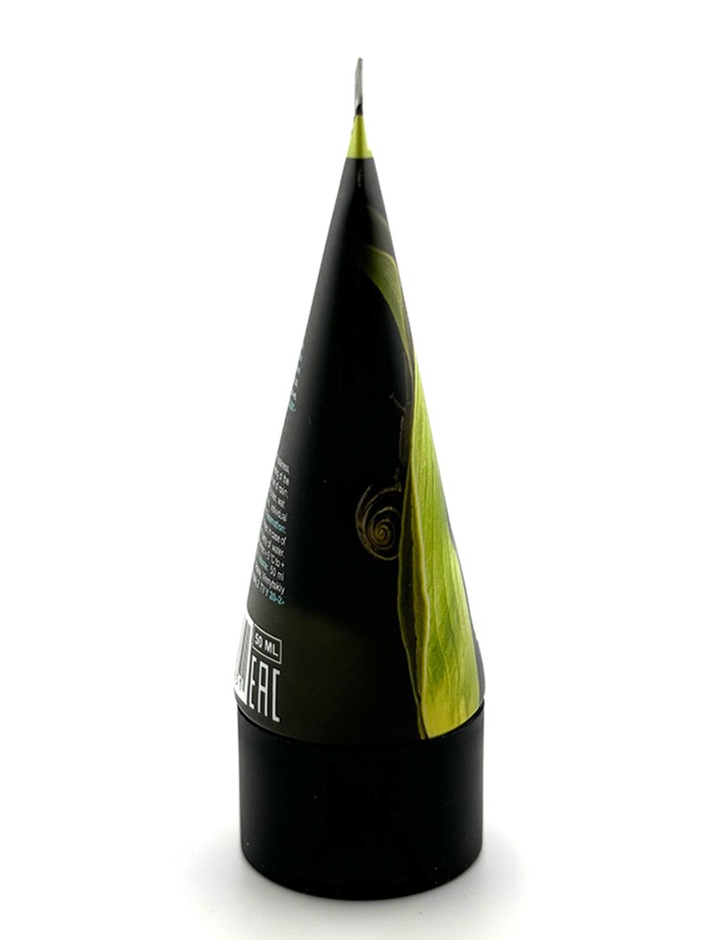 Może przedstawiać: Czarno-zielona tubka kosmetyczna z stożkowatą g&oacute;rą i cylindryczną podstawą. Tubka ma zielony wz&oacute;r liścia i tekst. Podstawa jest czarna, a g&oacute;ra ma kształt spiczastego stożka.