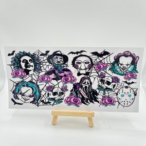 Könnte beinhalten: Eine Blatt mit Horrorfilm-Charakteraufklebern mit ikonischen Charakteren wie Freddy Krueger, Jason Voorhees und Michael Myers. Die Aufkleber sind schwarzweiß mit violetten Akzenten und zeigen Rosen und Spinnweben.