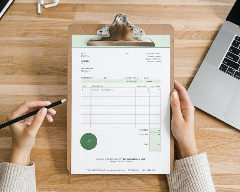 May include: A brown wooden clipboard holding a white invoice template with sage green accents. The document features fields for date, invoice number, customer ID, salesperson, job, payment terms, and a table for quantity, description, unit price, and line total.