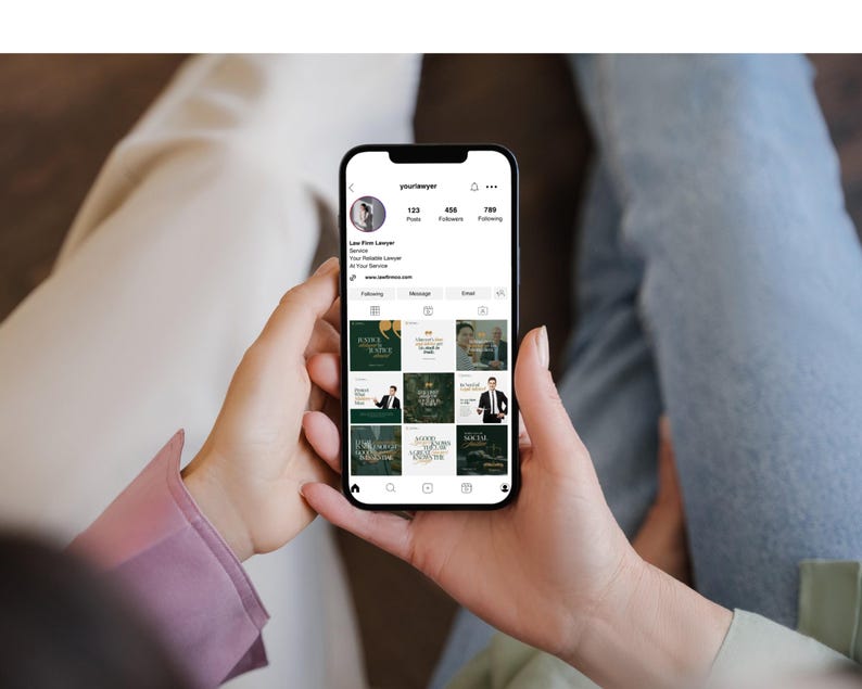 May include: A person holding a black smartphone displaying a social media profile. The profile showcases a law firm's branding with a dark green and gold color scheme. The screen displays the username "yourlawyer" and various posts.