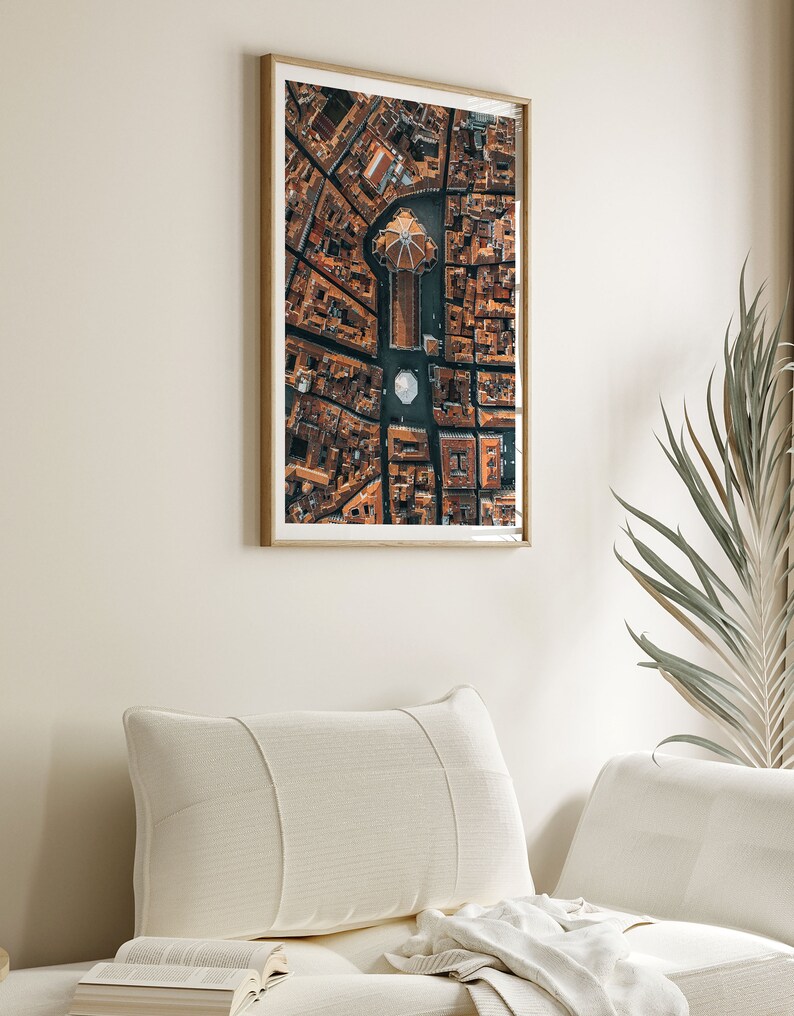 May include: An aerial photograph of a city with a large, domed building in the center. The buildings are all brown and the streets are narrow. The photo is framed in a wooden frame.
