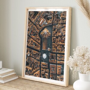 May include: An aerial photograph of a city with a large, domed building in the center. The building is surrounded by smaller buildings and streets. The photo is taken from a high angle, giving a bird's-eye view of the city.