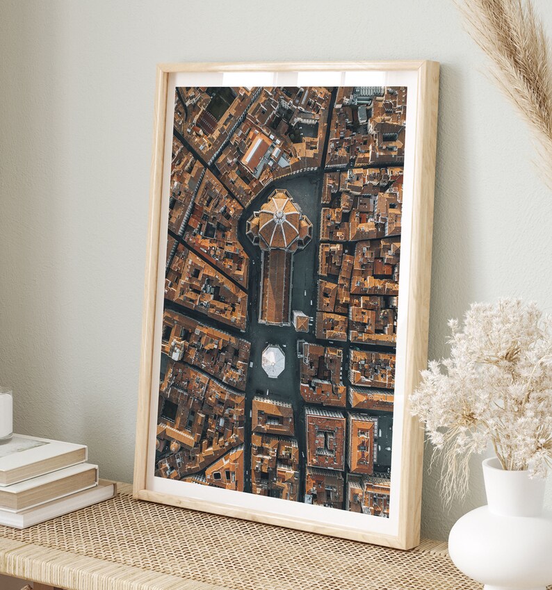 May include: An aerial photograph of a city with a large, domed building in the center. The building is surrounded by smaller buildings and streets. The photo is taken from a high angle, giving a bird's-eye view of the city.