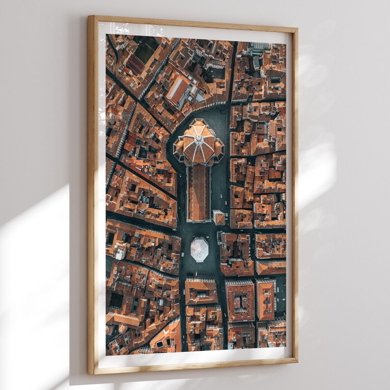 May include: An aerial photograph of a city with a large, domed building in the center. The building is surrounded by smaller buildings and streets. The photo is taken from a high angle, giving a bird's-eye view of the city.