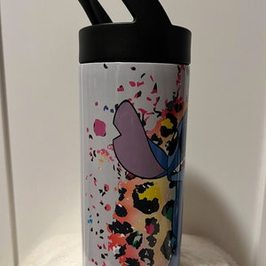 May include: A white stainless steel water bottle with a black lid and handle. The bottle has a colorful design featuring a cartoon character, Stitch, from the Disney movie Lilo & Stitch, with a leopard print background.