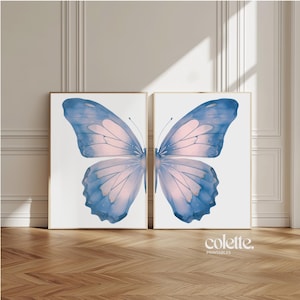 May include: Two printable art prints featuring a large blue and pink butterfly with gold accents. The butterfly is split in half, with each half on a separate print. The prints are on a white background.