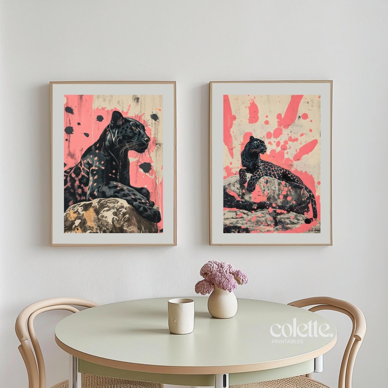 May include: Two framed prints of black panthers on a pink background with white splatter paint. The panther in the left print is lying down and the panther in the right print is sitting up.