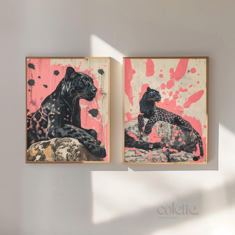 May include: Two framed prints of black panthers on pink backgrounds with white paint splatters. The panthers are in different poses, one is sitting and the other is lying down.