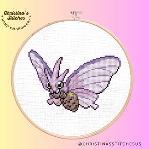 May include: A cross-stitch embroidery hoop featuring a purple and white butterfly with a brown cocoon. The hoop is white with a wooden frame. The text "Christina's Stitches" is in the upper left corner of the hoop.