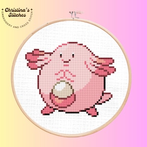 May include: A cross-stitch embroidery of a pink cartoon character in a wooden hoop. The character has a round body, small arms, and a white egg. The text "Christina's Stitches" is printed on the hoop.