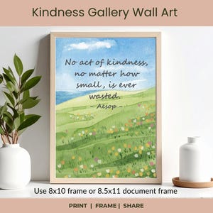 May include: A framed watercolor print with a quote: "No act of kindness, no matter how small, is ever wasted." The artwork depicts a green field with flowers, a blue sky, and a body of water. The frame is light-colored.