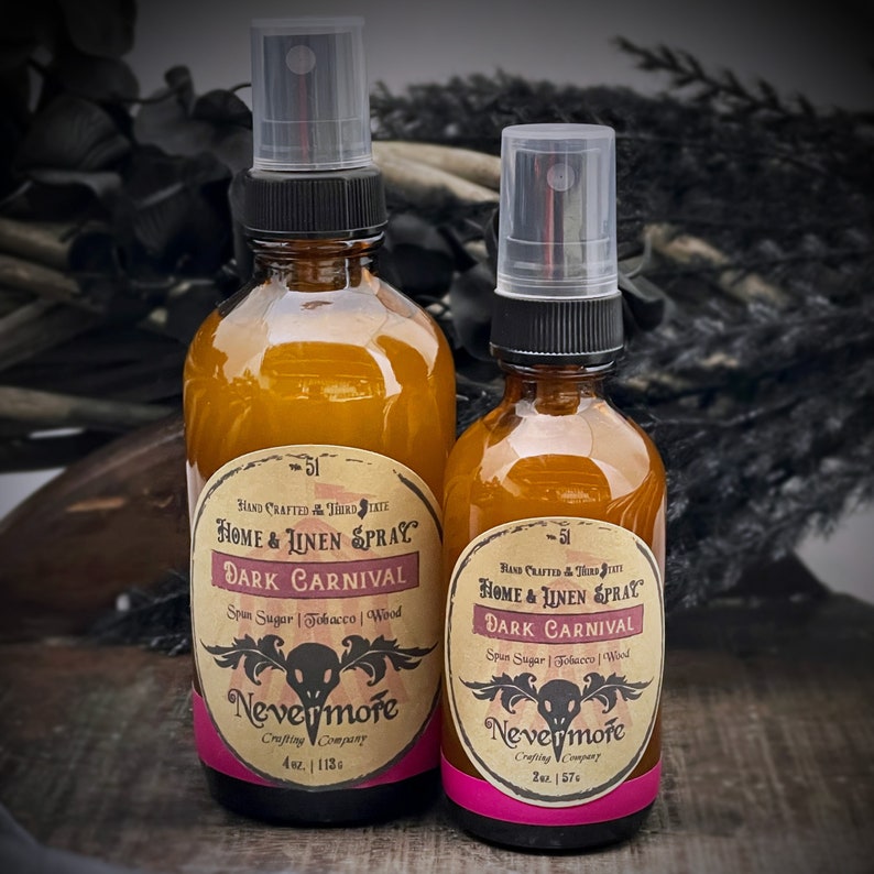 Peut inclure: Deux flacons en verre ambr&eacute; avec des vaporisateurs noirs et des &eacute;tiquettes. Les &eacute;tiquettes sont de couleur cr&egrave;me avec du texte noir qui indique "HAND CRAFTED THIRD STATE HOME & LINEN SPRAY DARK CARNIVAL Spin Sugar | Tobacco | Wood Nevermore Crafting Company" et la taille du flacon en onces. Le plus petit flacon est de 2 oz et le plus grand de 4 oz. Les flacons sont sur une surface brun fonc&eacute;.