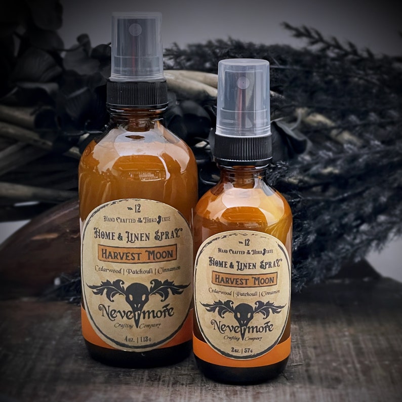 Peut inclure: Deux flacons en verre ambr&eacute; avec des vaporisateurs noirs et des &eacute;tiquettes. Les &eacute;tiquettes sont brunes avec du texte blanc qui dit "Hand Crafted Third State Home & Linen Spray Harvest Moon Cedarwood | Patchouli | Cinnamon Nevermore Crafting Company" et les tailles "4 oz. | 118 ml" et "2 oz. | 57 ml".
