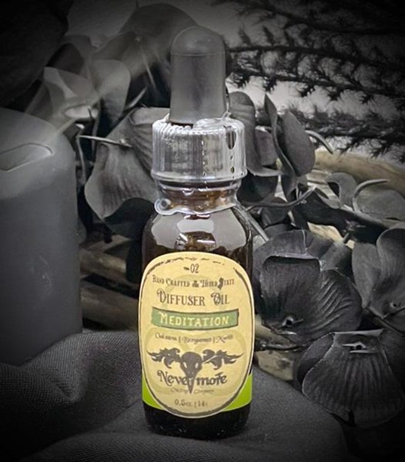 May include: A small, dark glass bottle of diffuser oil with a black dropper. The label reads "Meditation" and "Nevermore". The bottle is filled with a brown liquid and is 0.5 fl oz (14 ml).
