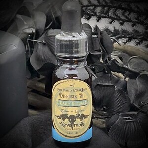 May include: A small glass bottle of "Daily Rituals" diffuser oil with a black dropper. The label reads "Tobacco | Spices" and "Nevermore". The bottle contains 0.5 fl oz (14 ml) of oil and has a light blue band at the bottom.