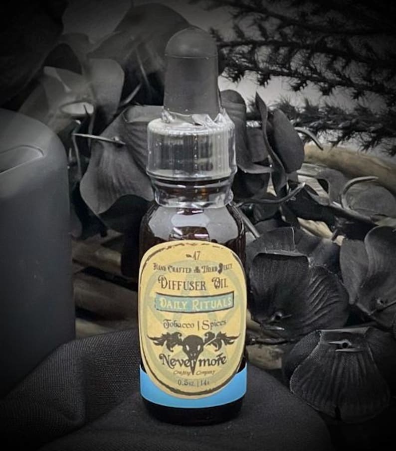 May include: A small glass bottle of "Daily Rituals" diffuser oil with a black dropper. The label reads "Tobacco | Spices" and "Nevermore". The bottle contains 0.5 fl oz (14 ml) of oil and has a light blue band at the bottom.