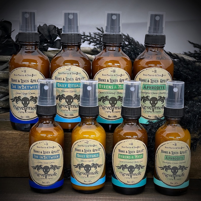 Peut inclure: Huit flacons en verre ambr&eacute; avec des vaporisateurs noirs et des &eacute;tiquettes bleues. Les flacons sont remplis d'un liquide clair et portent une &eacute;tiquette blanche avec du texte noir. Le texte sur les &eacute;tiquettes indique "Home & Linen Spray" et comprend une vari&eacute;t&eacute; de parfums, notamment "The In Between", "Daily Rituals", "Sirens & Mist", "Aphrodite" et "Nevermore Crafting Company".