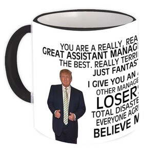 Może przedstawiać: Biały ceramiczny kubek z czarnym uchwytem i obramowaniem. Kubek przedstawia zdjęcie mężczyzny w garniturze i tekst "YOU ARE A REALLY GREAT ASSISTANT MANAGER...LOSER...BELIEVE ME."