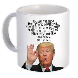 Pode incluir: Caneca de cerâmica branca com uma alça. Apresenta um retrato de um homem e o texto: "YOU ARE THE BEST FULL STACK DEVELOPER. VERY SPECIAL. VERY TALENTED. REALLY TERRIFIC. HIGH IQ. OTHER DEVELOPERS? FAKE NEWS. BELIEVE ME."