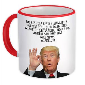 May include: White ceramic mug with a red handle and rim. The mug features a portrait of a man and German text. The text includes phrases like "You are the best stepmother" and "Fake News."