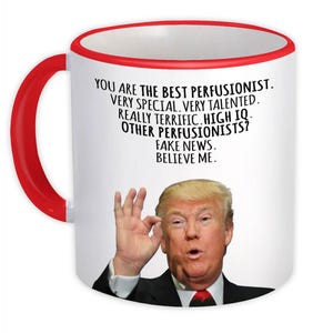 Pode incluir: Uma caneca de cerâmica branca com uma alça e borda vermelhas. A caneca apresenta o texto "YOU ARE THE BEST PERFUSIONIST. VERY SPECIAL. VERY TALENTED. REALLY TERRIFIC. HIGH IQ. OTHER PERFUSIONISTS? FAKE NEWS. BELIEVE ME." com uma foto de um homem.