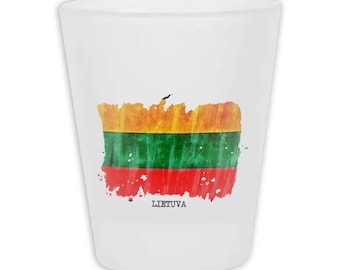 May include: White shot glass with a painted design of the Lithuanian flag. The flag design features horizontal stripes of yellow, green, and red, with the word "LIETUVA" printed below the flag.
