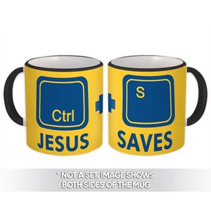 May include: A yellow coffee mug with a black handle and rim. The mug features a blue keyboard key design with the words "Ctrl JESUS" on one side and "S SAVES" on the other. The text "NOT A SET. IMAGE SHOWS BOTH SIDES OF THE MUG" is at the bottom.