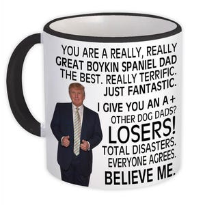 May include: White ceramic mug with a black handle and rim. The mug features a photo of a man in a suit and tie, along with text that reads "YOU ARE A REALLY, REALLY GREAT BOYKIN SPANIEL DAD".