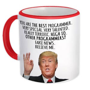 Op de afbeelding: Witte keramische mok met een rode handgreep en rand. De mok heeft een portret van een man en de tekst: "YOU ARE THE BEST PROGRAMMER. VERY SPECIAL. VERY TALENTED. REALLY TERRIFIC. HIGH IQ. OTHER PROGRAMMERS? FAKE NEWS. BELIEVE ME."