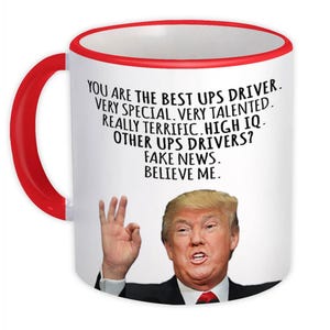 Op de afbeelding: Een witte keramische koffiemok met een rode rand. De mok heeft een zwart-witte afbeelding van Donald Trump met de tekst "You are the best UPS driver. Very special. Very talented. Really terrific. High IQ. Other UPS drivers? Fake news. Believe me."
