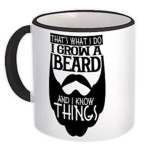 Puede incluir: Taza de cerámica blanca con asa y borde negros. La taza presenta un gráfico negro de barba y bigote, con el texto "THAT'S WHAT I DO I GROW A BEARD AND I KNOW THINGS."