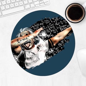 Op de afbeelding: Een ronde, marineblauwe muismat met een cartoonafbeelding van Albert Einstein die dabt. Op Einsteins arm staat de vergelijking E=mc² getatoeëerd. De achtergrond bevat wiskundige formules en een zwart penseelstrekenontwerp. Een kopje koffie en een toetsenbord zijn zichtbaar.