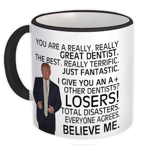 Puede incluir: Taza de cerámica blanca con borde y asa negros. La taza presenta una imagen en blanco y negro de un hombre con el texto "You are a really, really great dentist. The best. Really terrific. Just fantastic. I give you an A+ Other dentists? Losers! Total disasters. Everyone agrees. Believe me."