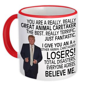 May include: White ceramic mug with a red handle and rim. The mug features a picture of a man in a suit and text that reads, "YOU ARE A REALLY, REALLY GREAT ANIMAL CARETAKER...BELIEVE ME."
