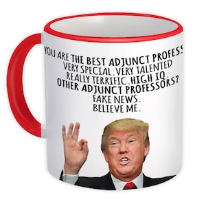 Puede incluir: Taza de cerámica blanca con asa y borde rojos. La taza presenta un retrato de un hombre y el texto "YOU ARE THE BEST ADJUNCT PROFESS...FAKE NEWS. BELIEVE ME."