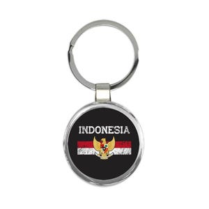 Puede incluir: Un llavero plateado con una etiqueta redonda en blanco y negro que muestra la bandera de Indonesia y la palabra "INDONESIA" en texto blanco.