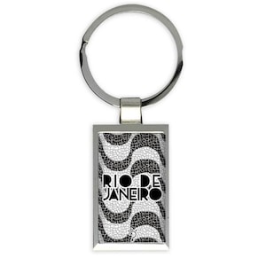 Puede incluir: Llavero de plata con una imagen rectangular en blanco y negro de un patrón de onda con el texto "RIO DE JANEIRO" en negro.