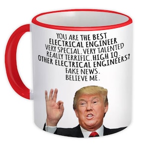 Peut inclure: Une tasse en céramique blanche avec une anse et un bord rouges. La tasse présente le texte "YOU ARE THE BEST ELECTRICAL ENGINEER...FAKE NEWS. BELIEVE ME." Un portrait d'homme est également présent.