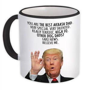 Puede incluir: Taza de café blanca con borde y asa negros. La taza presenta una foto de Donald Trump y el texto "You are the best Akbash Dad. Very special. Very talented. Really terrific. High IQ. Other dog dads? Fake news. Believe me."