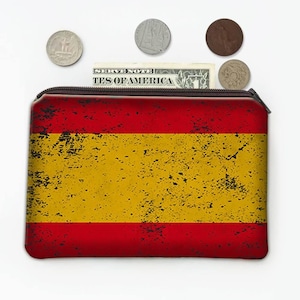 Op de afbeelding: Een rechthoekige portemonnee met ritssluiting met het Spaanse vlagontwerp in rood en geel. De portemonnee is open en toont een dollarbiljet en verschillende munten. Het ontwerp heeft een vintage uitstraling.