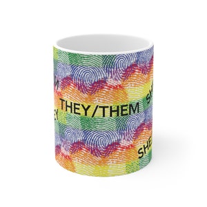 May include: White ceramic mug with a rainbow fingerprint pattern and the text "THEY/THEM" in black.