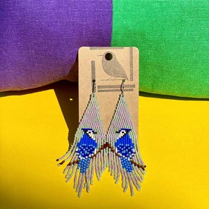 Pendientes de arrendajo azul con flecos y cuentas hechos a mano: joyas llamativas en tonos azules y pastel.