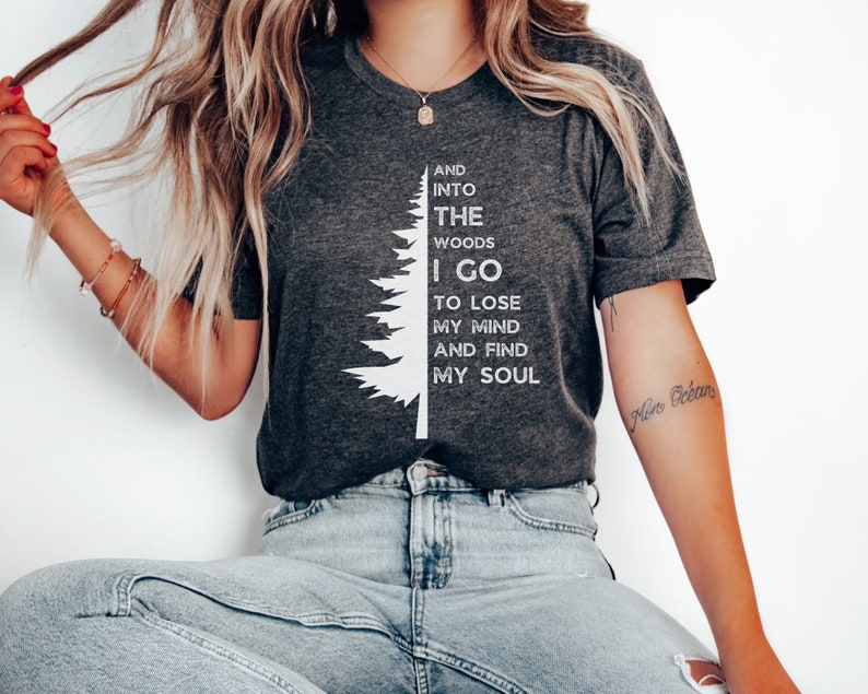 Cute unisex pine tree design with half a tree on the left and text on the right. Text reads 'and into the woods I go to lose my mind and find my soul'.